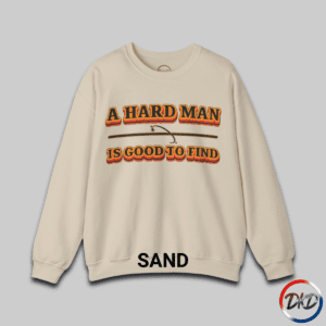 A Sand unisex fit crewneck sweatshirt featuring bold retro orange‑and‑brown typography that reads “A Hard Man Is Good to Find,” with a vintage curved accent line and star between the text lines.