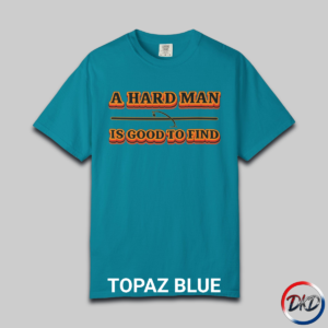 A Topaz Blue Comfort Colors® 1717 T‑shirt featuring bold retro orange-and-black typography that reads “A Hard Man Is Good to Find,” with a small vintage accent graphic between the lines.