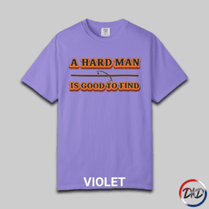 A Violet Comfort Colors® 1717 T‑shirt featuring bold retro orange-and-black typography that reads “A Hard Man Is Good to Find,” with a small vintage accent graphic between the lines.