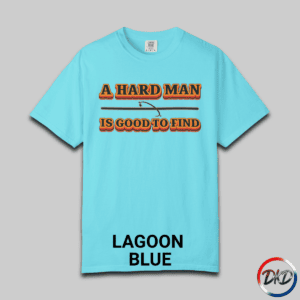 A Lagoon Blue Comfort Colors® 1717 T‑shirt featuring bold retro orange-and-black typography that reads “A Hard Man Is Good to Find,” with a small vintage accent graphic between the lines.